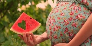 watermelon slice in pregnant hand